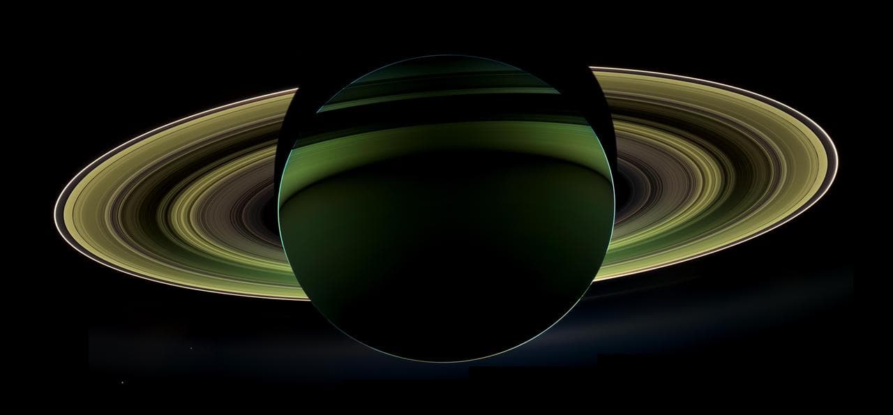 Saturn backlit by the Sun with its rings glowing, photographed by Cassini