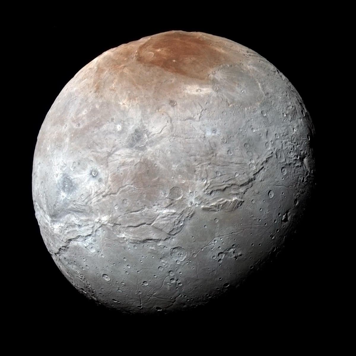 Charon, Pluto's largest moon, photographed in enhanced colour by New Horizons showing its reddish polar cap