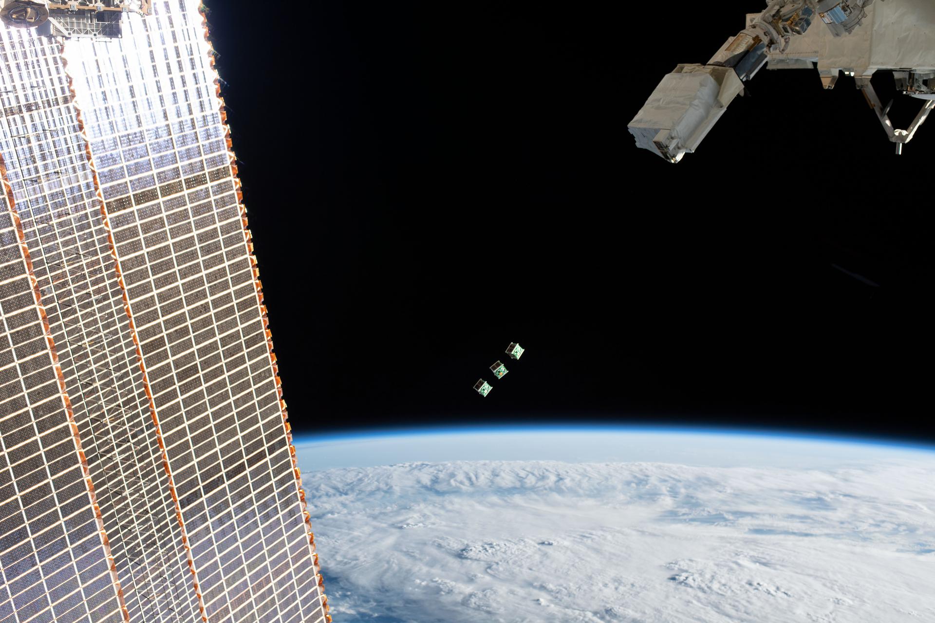 CubeSats being deployed from the International Space Station, demonstrating the miniaturized satellite technology that underpins orbital computing concepts
