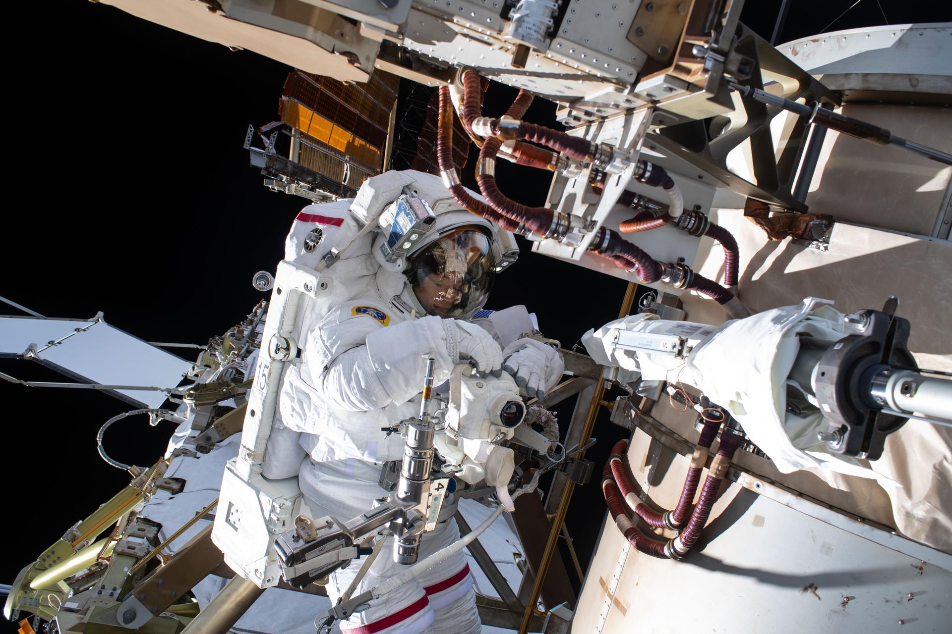 An astronaut working on solar array infrastructure during an ISS spacewalk, illustrating the power systems that could sustain orbital computing facilities