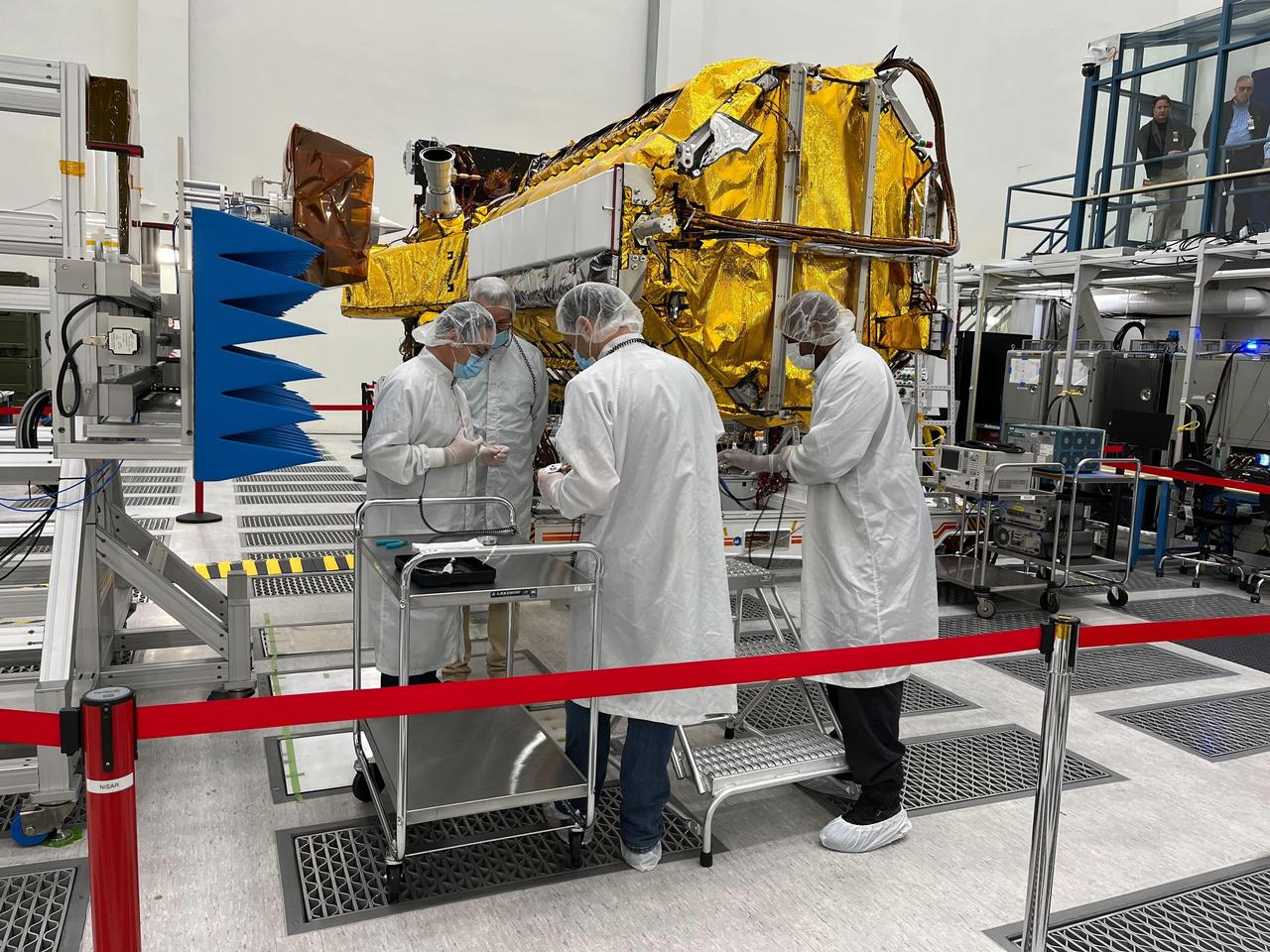 NASA and ISRO engineers working together on the NISAR satellite in a JPL clean room