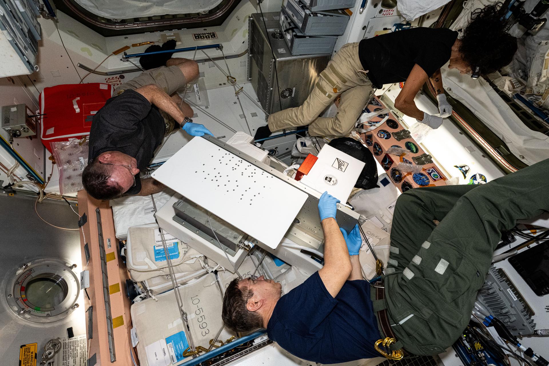 NASA astronauts testing the ArgUS Mission 1 computing hardware aboard the ISS, demonstrating space-grade computer processing and communications technology